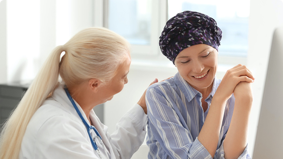 Female oncology doctor providing encouragement to female cancer patient.
